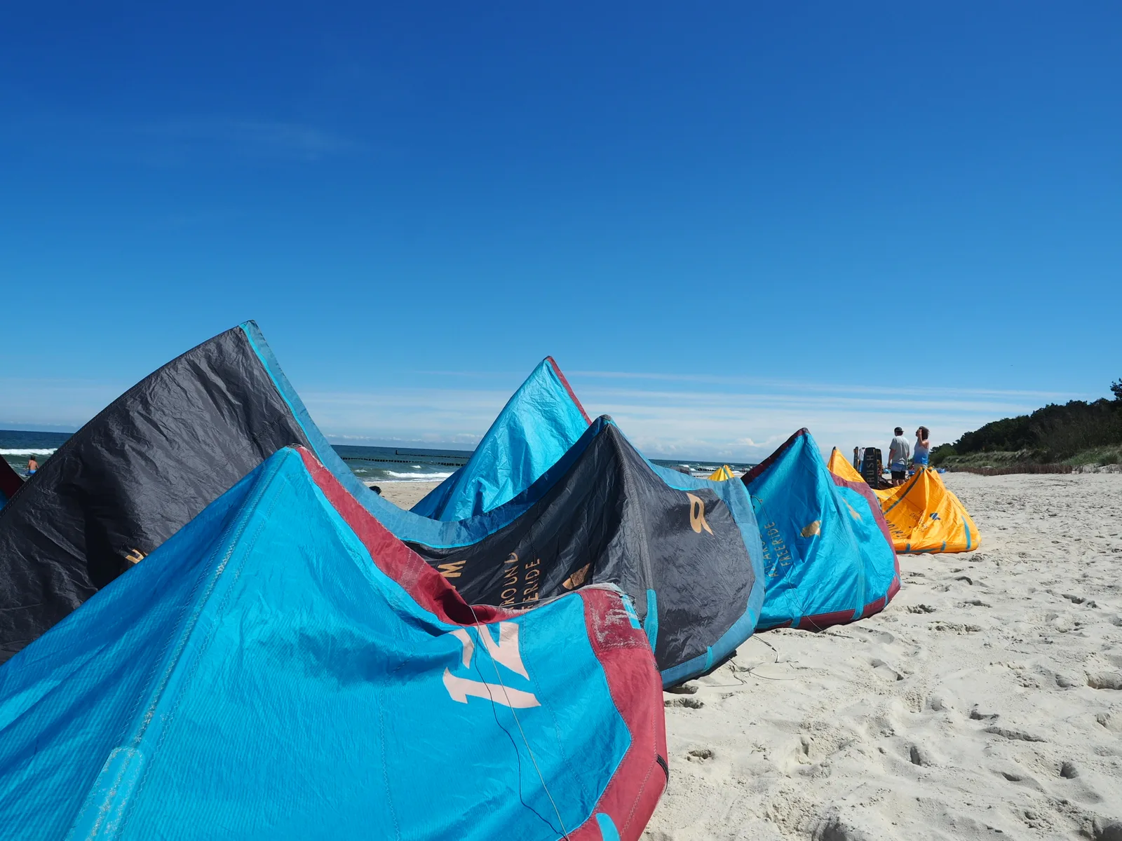 Latawce z wypożyczalni rozłożone na plaży